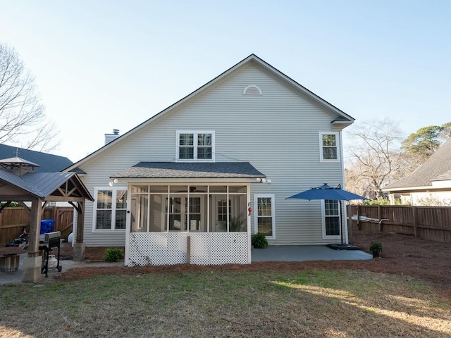 back of property with a gazebo, a lawn, a patio, and a sunroom