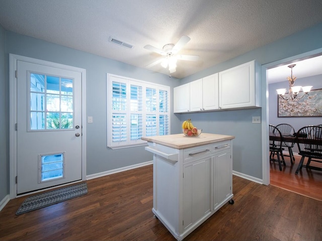 kitchen with dark wood finished floors, visible vents, white cabinets, and light countertops