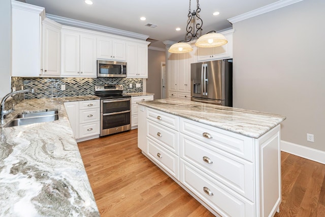 287 Commonwealth Rd, Mount Pleasant, SC 29466 - kitchen featuring appliances with stainless steel finishes, a sink, a center island, visible vents, and ornamental molding