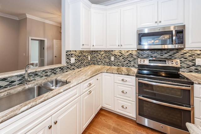 287 Commonwealth Rd, Mount Pleasant, SC 29466 - kitchen featuring backsplash, crown molding, appliances with stainless steel finishes, a sink, and white cabinetry