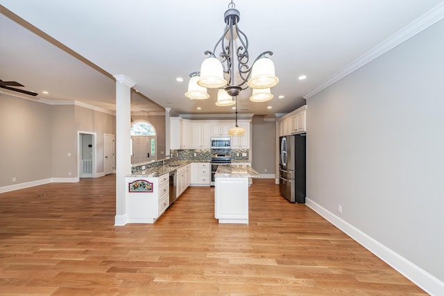287 Commonwealth Rd, Mount Pleasant, SC 29466 - kitchen featuring backsplash, light stone countertops, appliances with stainless steel finishes, and ornamental molding