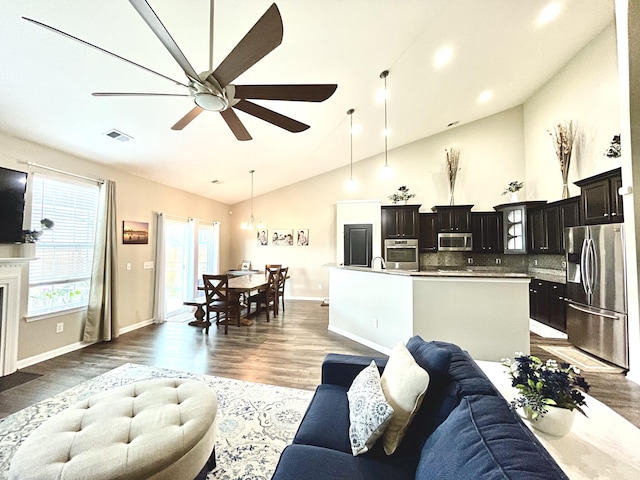 living room with ceiling fan, dark hardwood / wood-style flooring, sink, and high vaulted ceiling