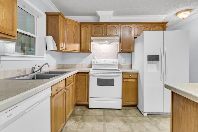 kitchen with tile countertops, white appliances, backsplash, sink, and a textured ceiling