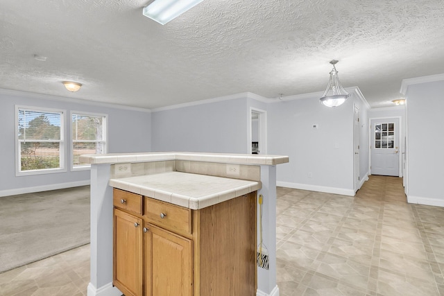 kitchen featuring ornamental molding, a textured ceiling, pendant lighting, tile countertops, and a center island