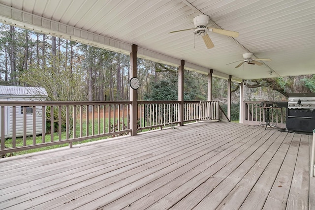 wooden terrace with ceiling fan and area for grilling