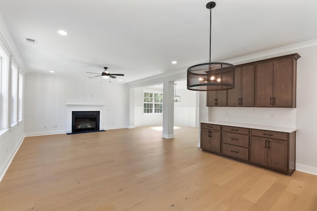 kitchen with decorative light fixtures, decorative backsplash, ceiling fan, dark brown cabinetry, and light wood-type flooring