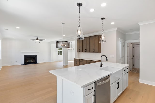 kitchen with dark brown cabinetry, sink, stainless steel dishwasher, a kitchen island with sink, and white cabinets