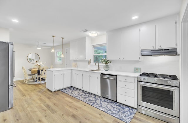 1515 Mulberry St, Charleston, SC 29407 - kitchen with stainless steel appliances, a sink, under cabinet range hood, a peninsula, and light countertops