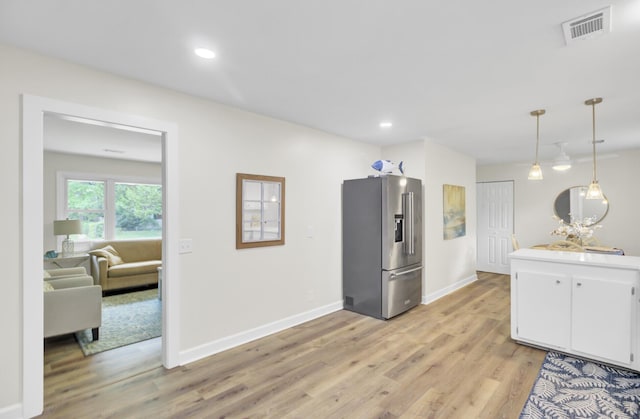 1515 Mulberry St, Charleston, SC 29407 - kitchen featuring stainless steel refrigerator with ice dispenser, white cabinets, light wood-style flooring, baseboards, and decorative light fixtures