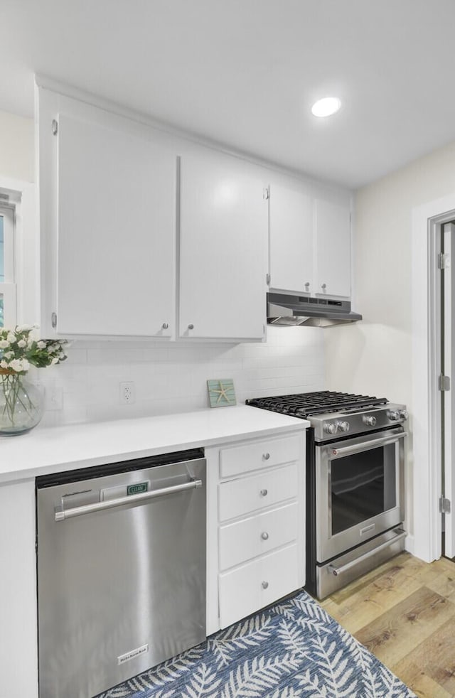 1515 Mulberry St, Charleston, SC 29407 - kitchen with appliances with stainless steel finishes, under cabinet range hood, white cabinets, tasteful backsplash, and recessed lighting