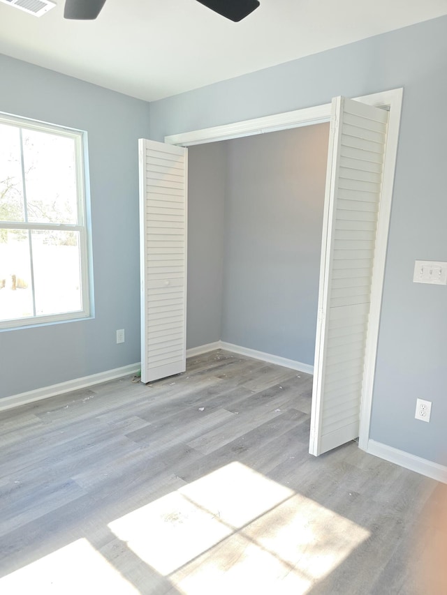 unfurnished bedroom with light wood-type flooring and a closet