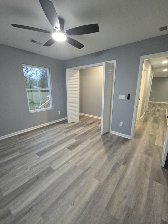 unfurnished bedroom with wood finished floors, visible vents, and baseboards