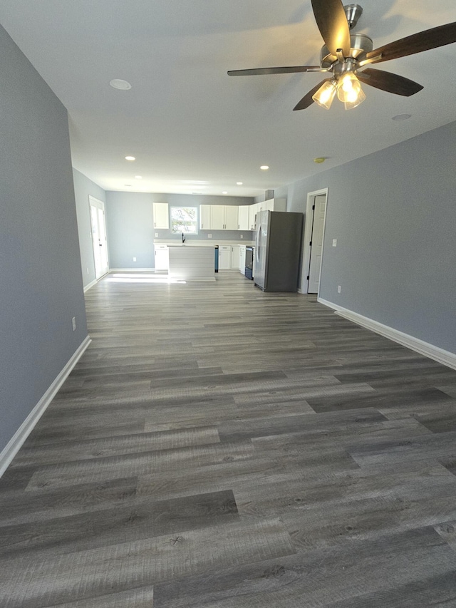 unfurnished living room with dark wood-style floors, recessed lighting, and baseboards