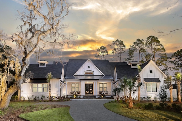 modern farmhouse with a lawn and covered porch