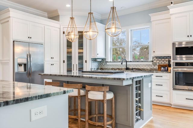 kitchen with dark stone counters, appliances with stainless steel finishes, and decorative backsplash