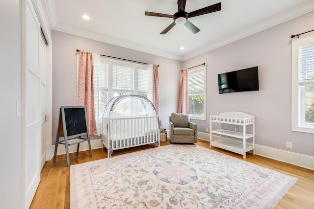 bedroom featuring a ceiling fan, wood finished floors, baseboards, recessed lighting, and crown molding