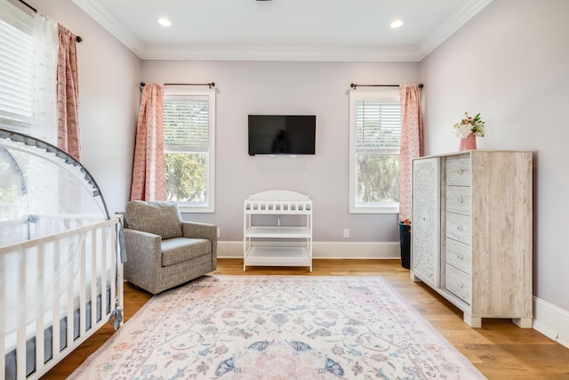 bedroom featuring multiple windows, light wood-style flooring, baseboards, and ornamental molding