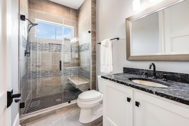 bathroom featuring vanity, a shower stall, and toilet