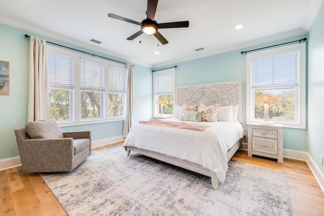 bedroom with visible vents, crown molding, and wood finished floors