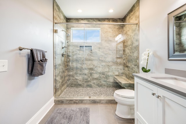 bathroom with tile patterned floors, toilet, a shower stall, baseboards, and vanity