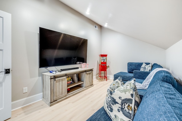 living area featuring baseboards, lofted ceiling, visible vents, and wood finished floors