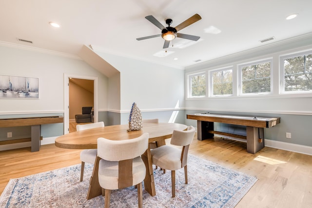 dining space with crown molding, visible vents, and light wood-type flooring