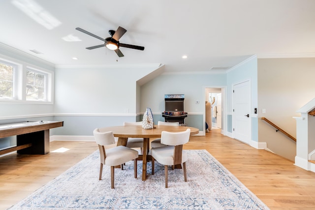 dining space with crown molding, light wood-style flooring, visible vents, and ceiling fan