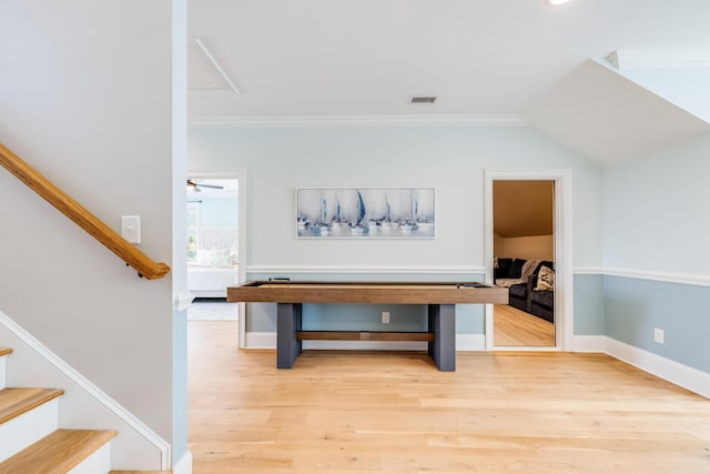 interior space with attic access, crown molding, stairs, and wood finished floors