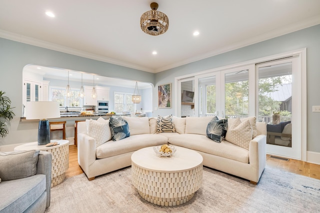 living room featuring recessed lighting, light wood-style floors, visible vents, and ornamental molding