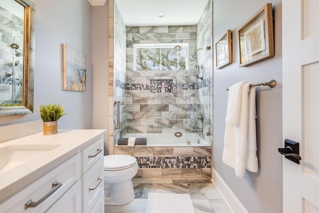 bathroom featuring vanity, toilet, marble finish floor, and tiled shower / bath combo