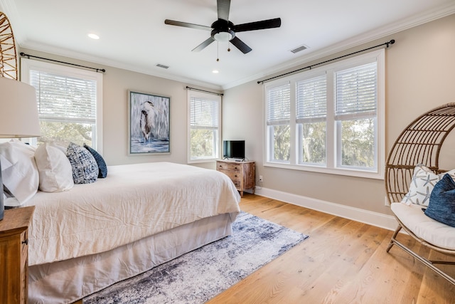 bedroom with visible vents, crown molding, baseboards, and wood finished floors