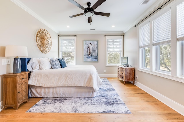 bedroom featuring visible vents, baseboards, light wood-style flooring, and crown molding