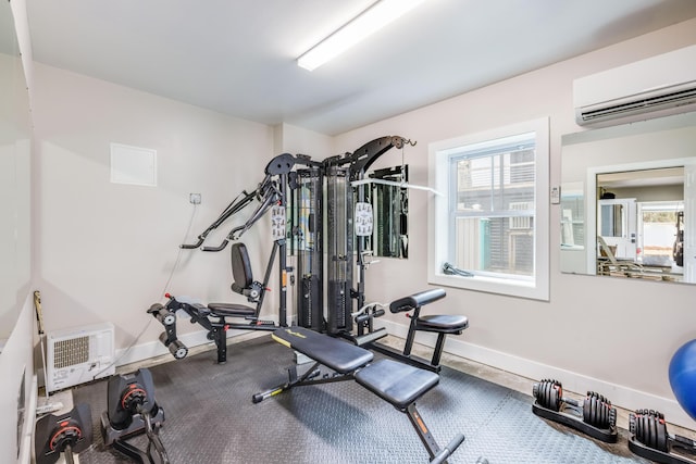 exercise area with a wealth of natural light, baseboards, and a wall mounted AC