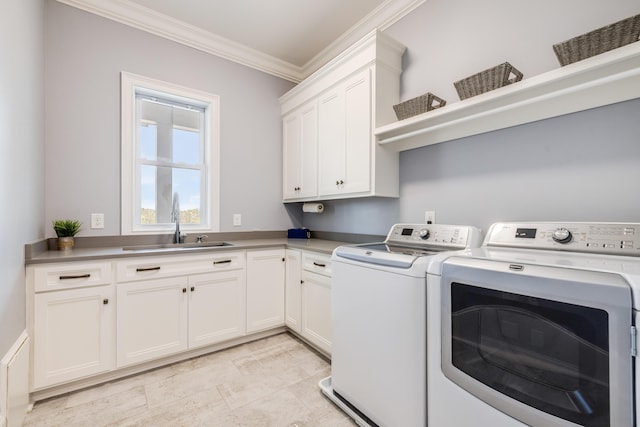 laundry room with cabinet space, washing machine and dryer, crown molding, and a sink