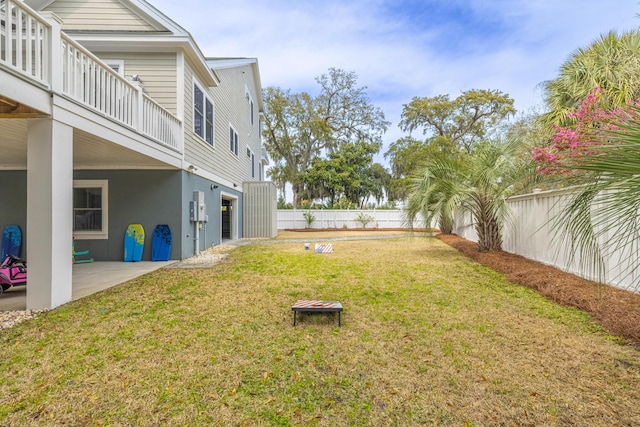 view of yard featuring a balcony, a patio area, a garage, and a fenced backyard