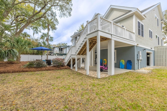 back of property featuring stairway, a lawn, a patio, and stucco siding