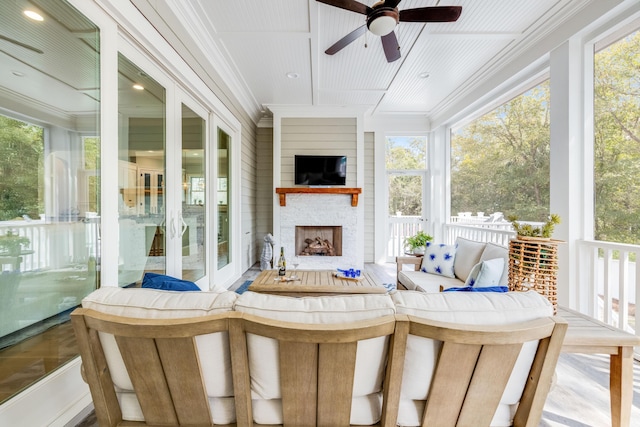 sunroom with exterior fireplace and ceiling fan