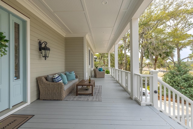 wooden deck with outdoor lounge area and covered porch