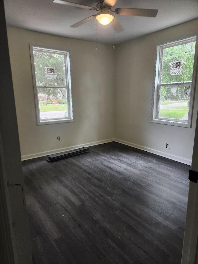 spare room featuring dark wood finished floors and baseboards