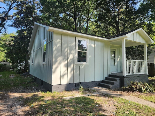 view of front of house with board and batten siding, crawl space, and a porch