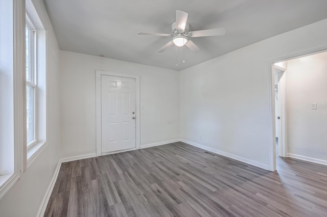 empty room with visible vents, baseboards, ceiling fan, and wood finished floors