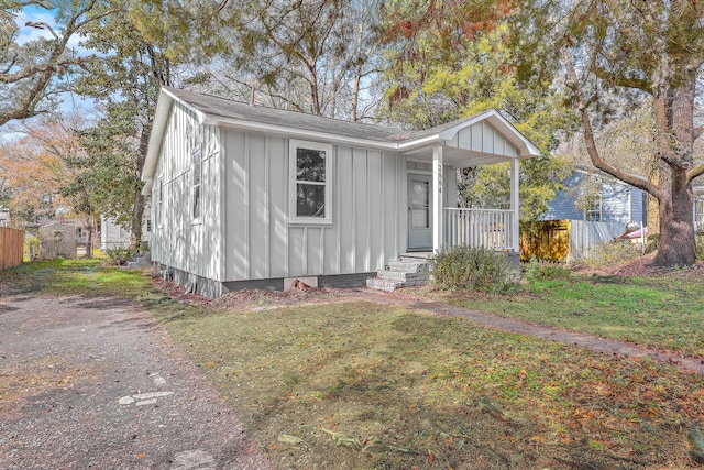 bungalow-style home featuring a porch, board and batten siding, and a front yard