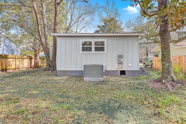 view of outdoor structure with an outdoor structure, central AC unit, and fence