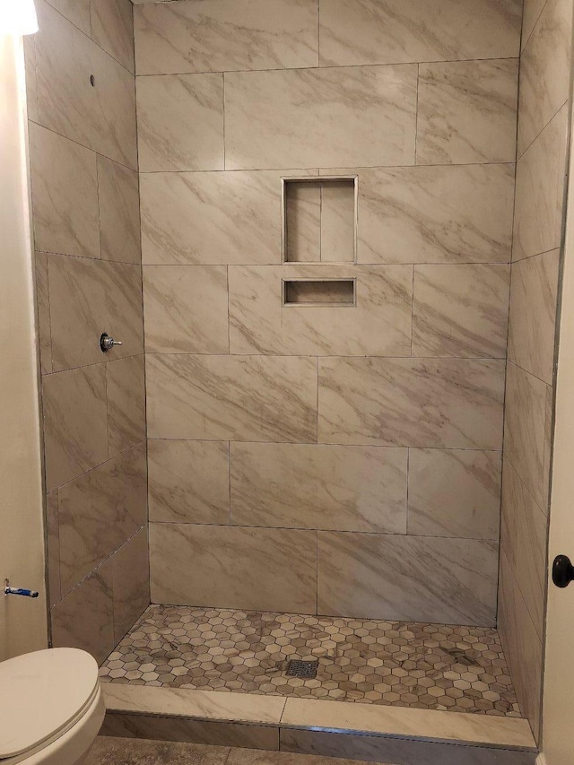 bathroom featuring toilet and a shower stall