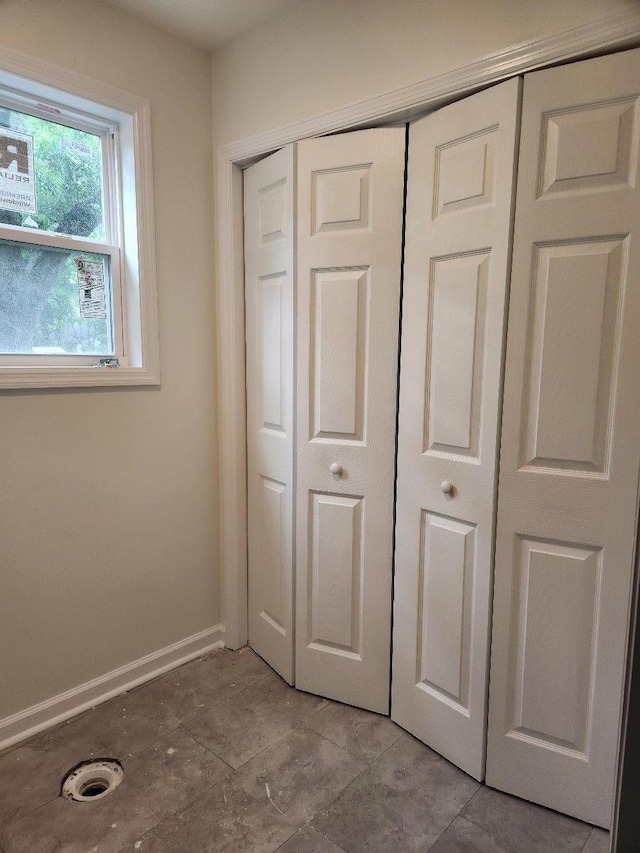 unfurnished bedroom with baseboards and a closet