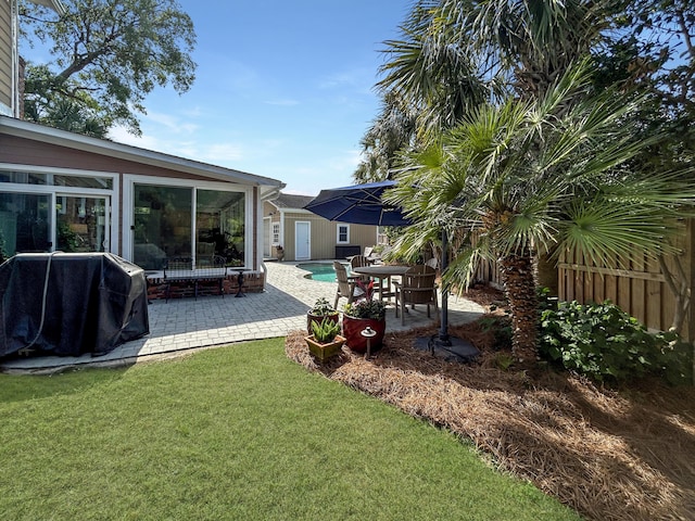 view of yard featuring fence, a patio area, and an outbuilding