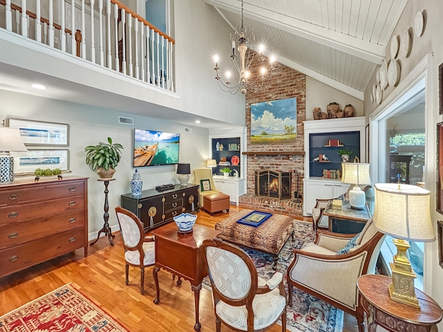 living room with beamed ceiling, a chandelier, visible vents, wood finished floors, and high vaulted ceiling