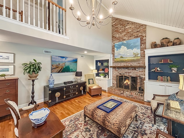living area featuring visible vents, wooden ceiling, an inviting chandelier, a fireplace, and wood finished floors