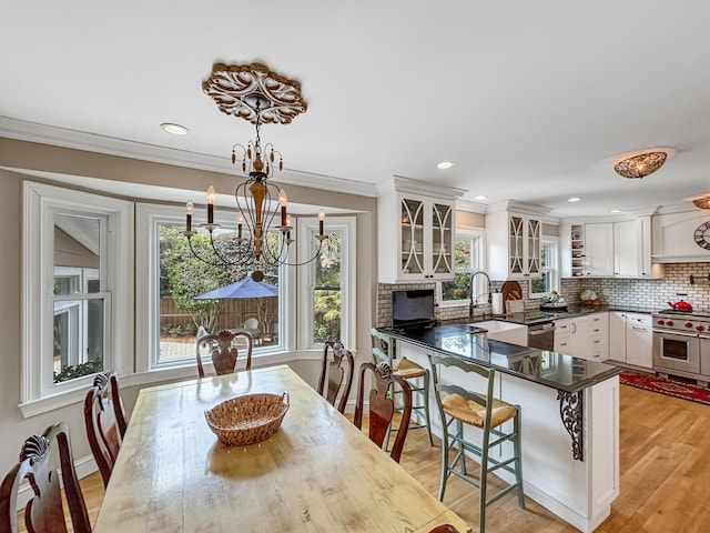 kitchen featuring dark countertops, stainless steel appliances, a kitchen bar, and a healthy amount of sunlight