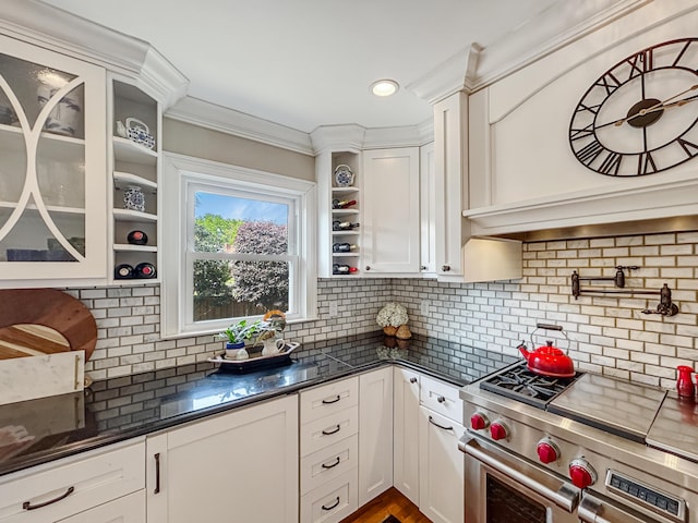 kitchen featuring high end stainless steel range oven, decorative backsplash, open shelves, white cabinets, and glass insert cabinets
